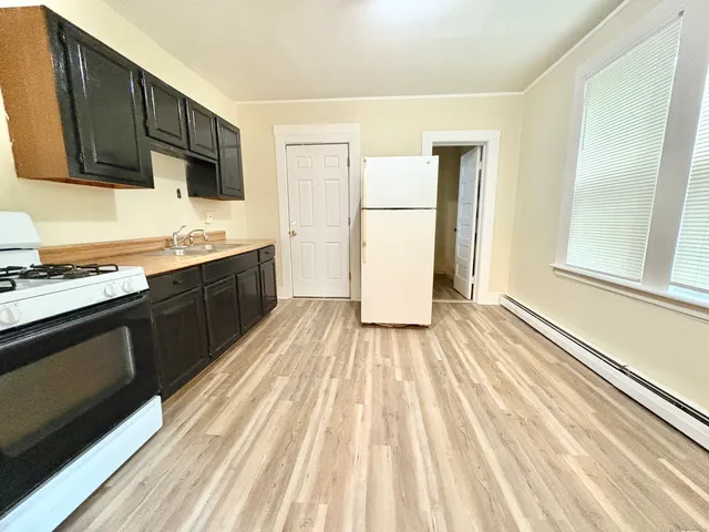 a kitchen with sink a refrigerator and cabinets