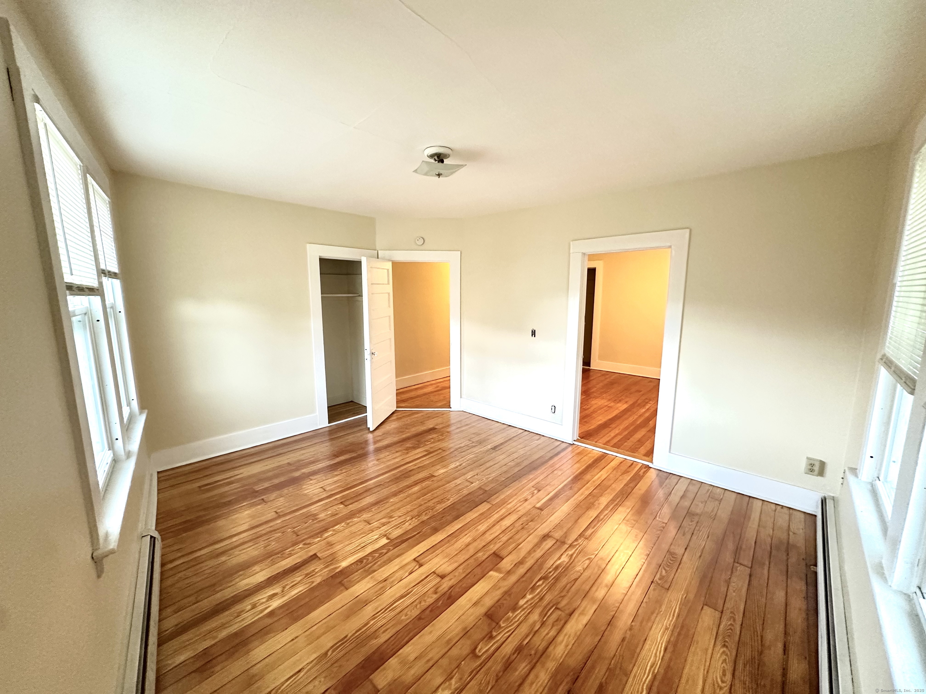 1019 West Main Street, Unit 3R Waterbury, CT 06708 - Photo 2 of 25 a view of an empty room with wooden floor and a window