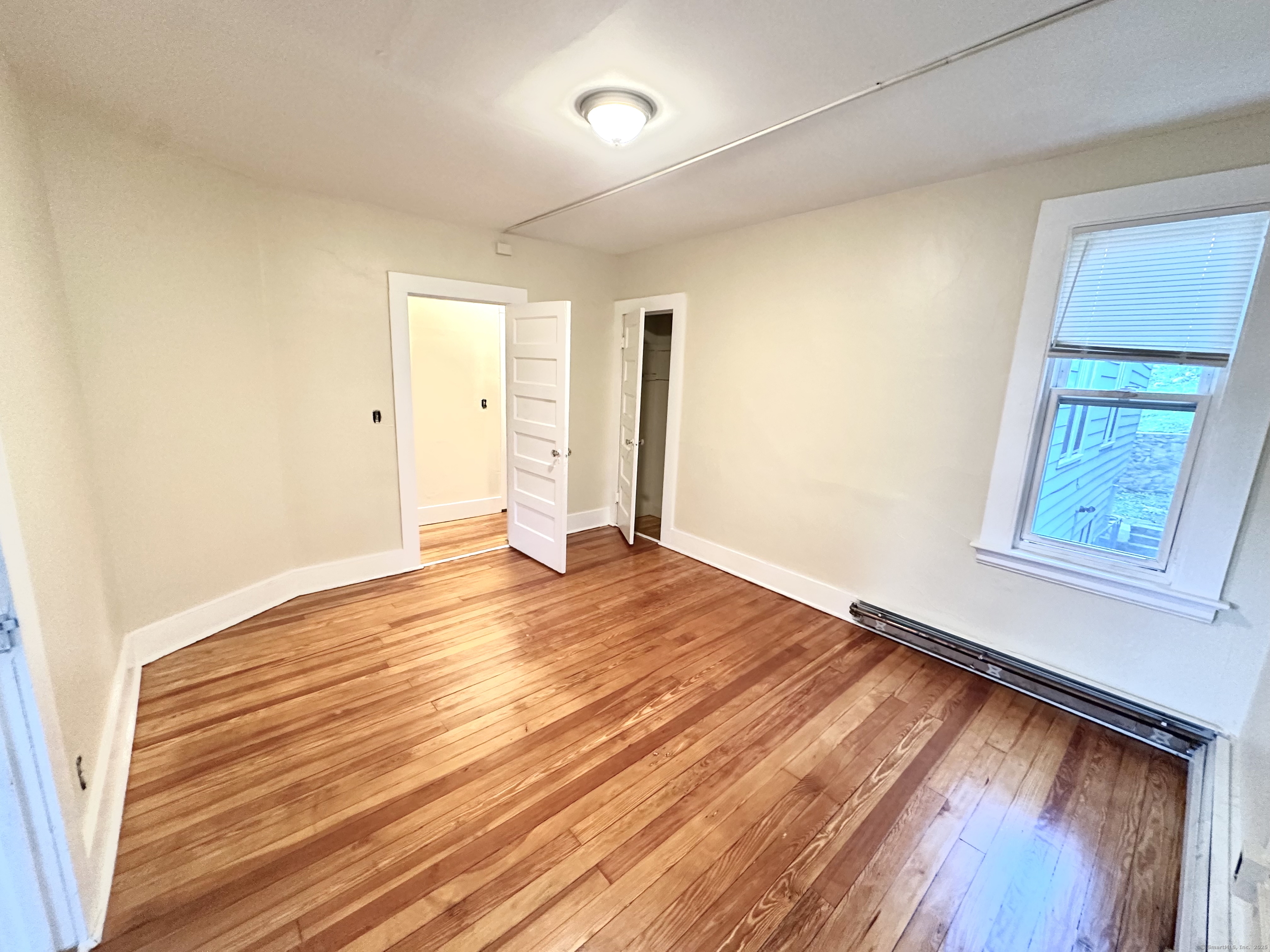 1019 West Main Street, Unit 3R Waterbury, CT 06708 - Photo 5 of 25 a view of empty room with wooden floor and fan