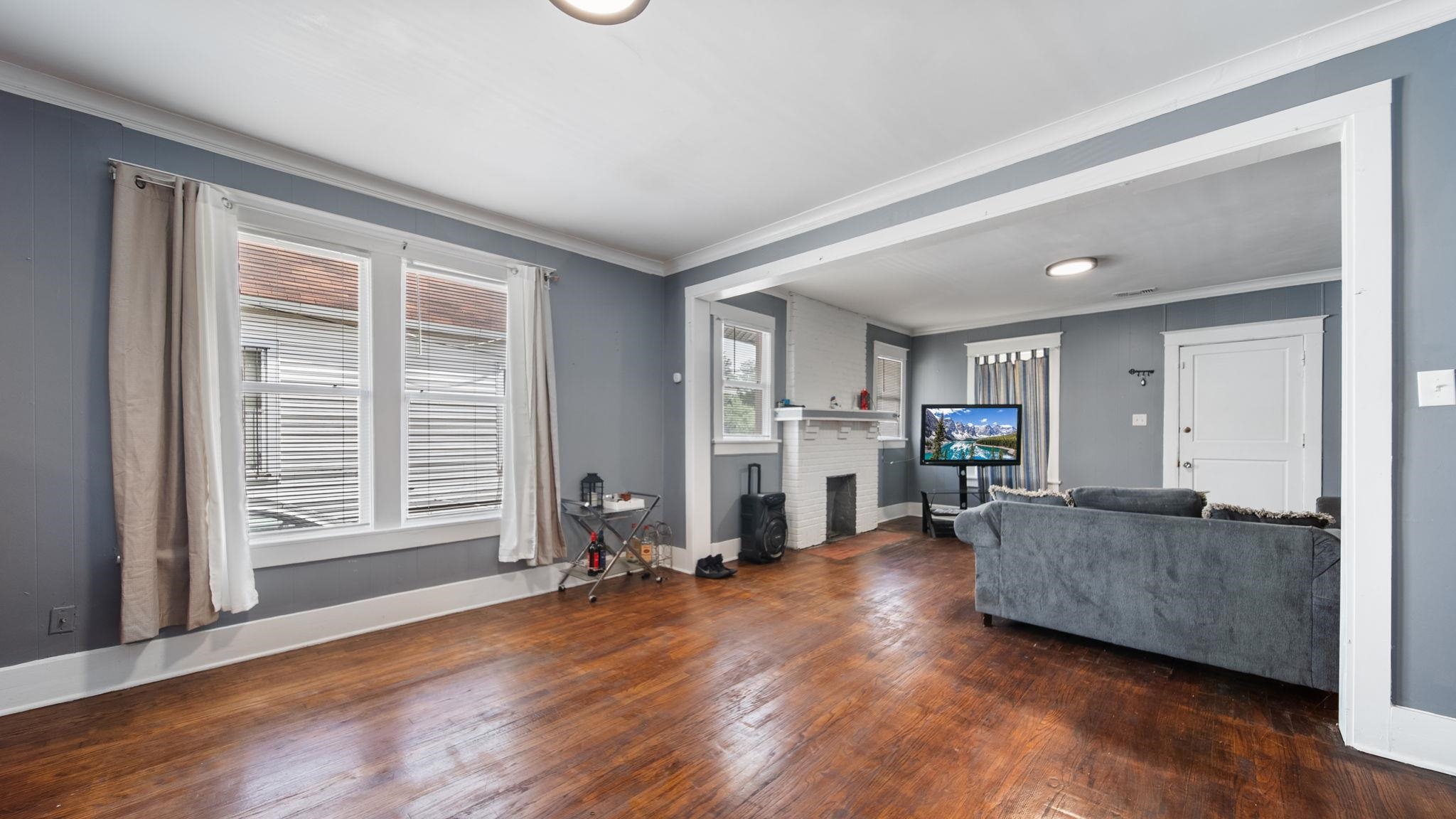 659 Decatur Street Memphis, TN 38107 - Photo 10 of 24 Living area featuring wood-finish flooring, white trim, recessed lighting, and a white-painted brick fireplace