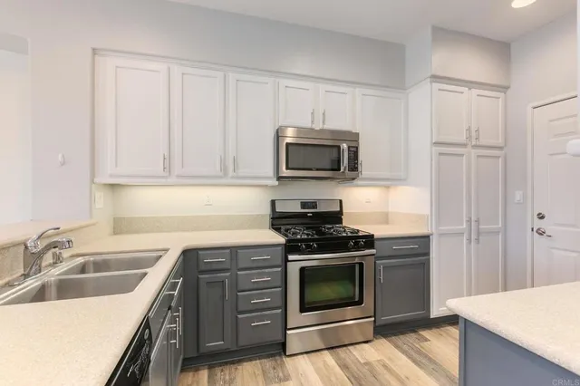 a kitchen with granite countertop a sink stove and microwave