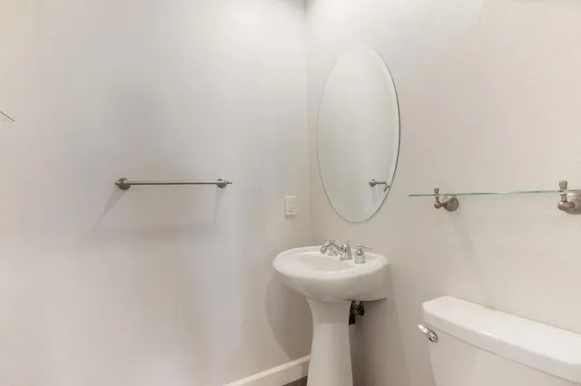 a bathroom with a sink toilet and a mirror