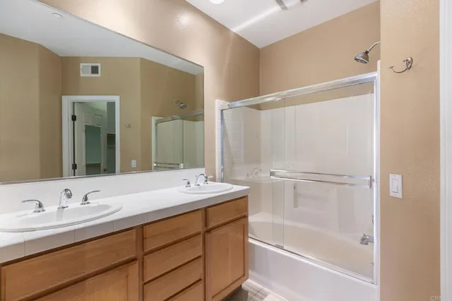 a bathroom with a granite countertop sink mirror and a bathtub