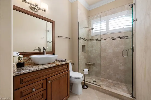 a bathroom with a granite countertop sink a toilet and shower