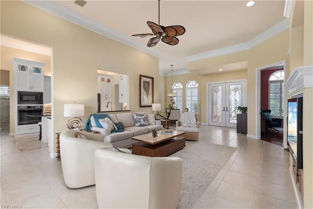 a living room with furniture kitchen view and a chandelier