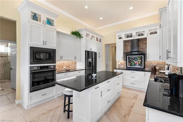 a kitchen with stainless steel appliances granite countertop a stove refrigerator and cabinets