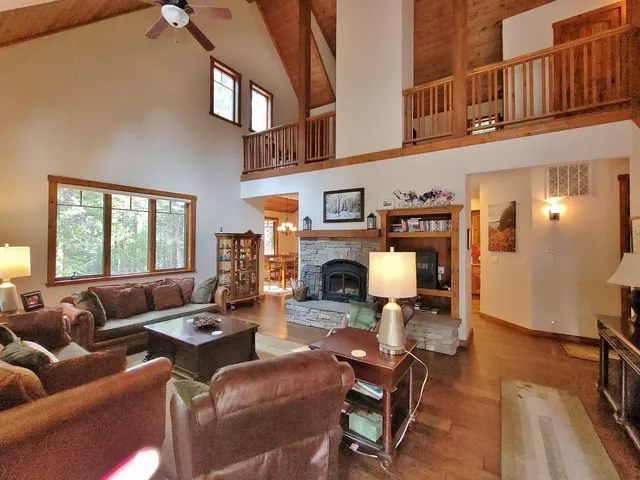 a living room with furniture a fireplace and a floor to ceiling window