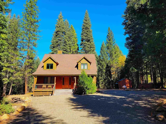 a front view of a house with a yard and trees