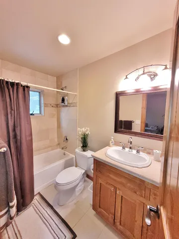 a bathroom with a sink a toilet a tub and shower