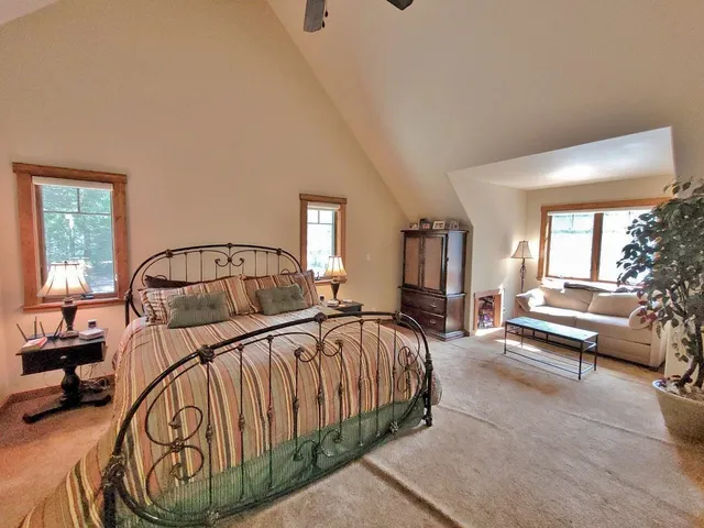 a bedroom with a bed window and a mirror