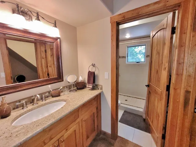 a bathroom with a sink vanity granite and a mirror