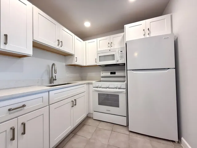 a white refrigerator freezer sitting inside of a kitchen