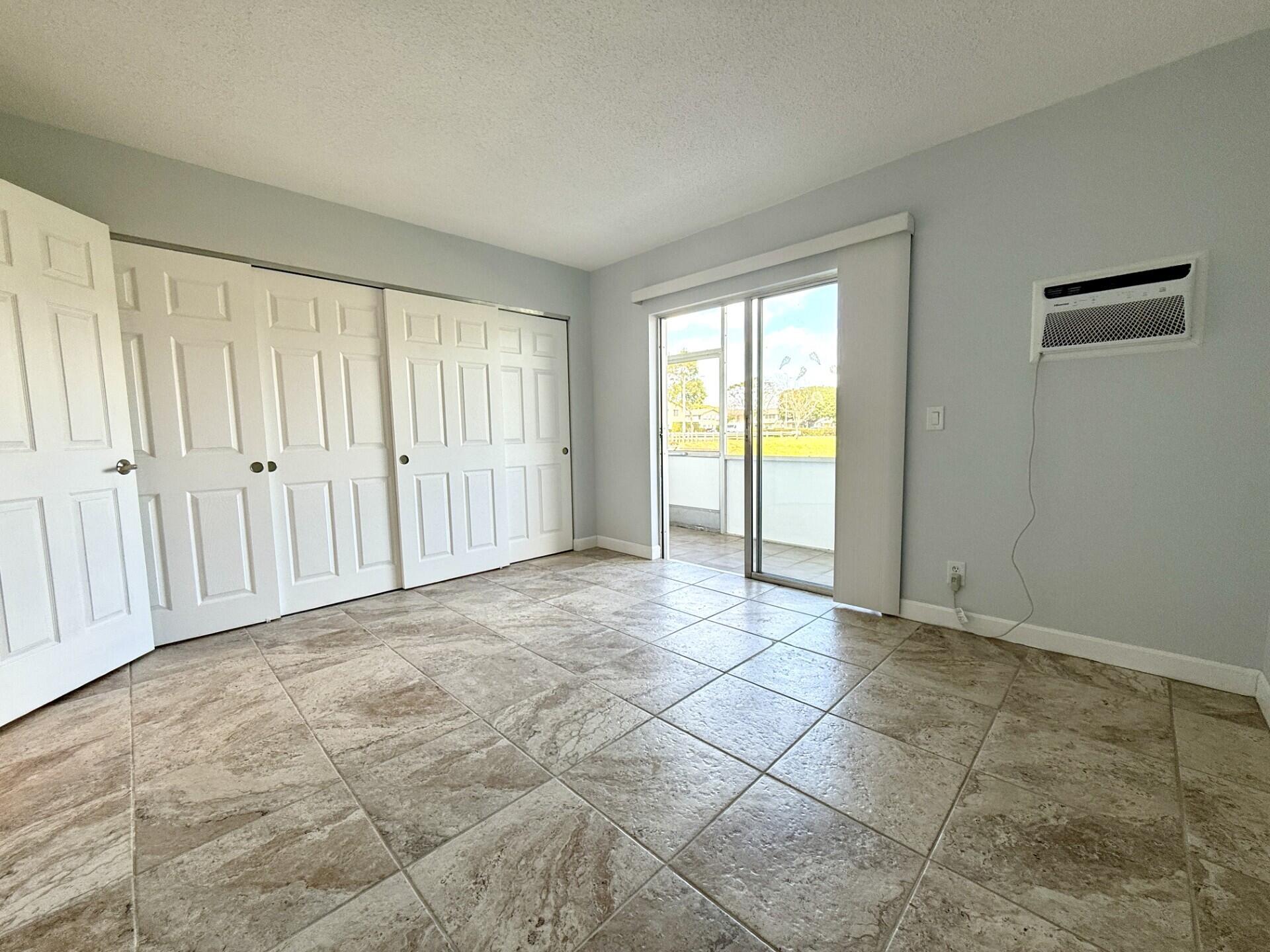 85 Berkshire D West Palm Beach, FL 33417 - Photo 5 of 17 a view of an empty room and window