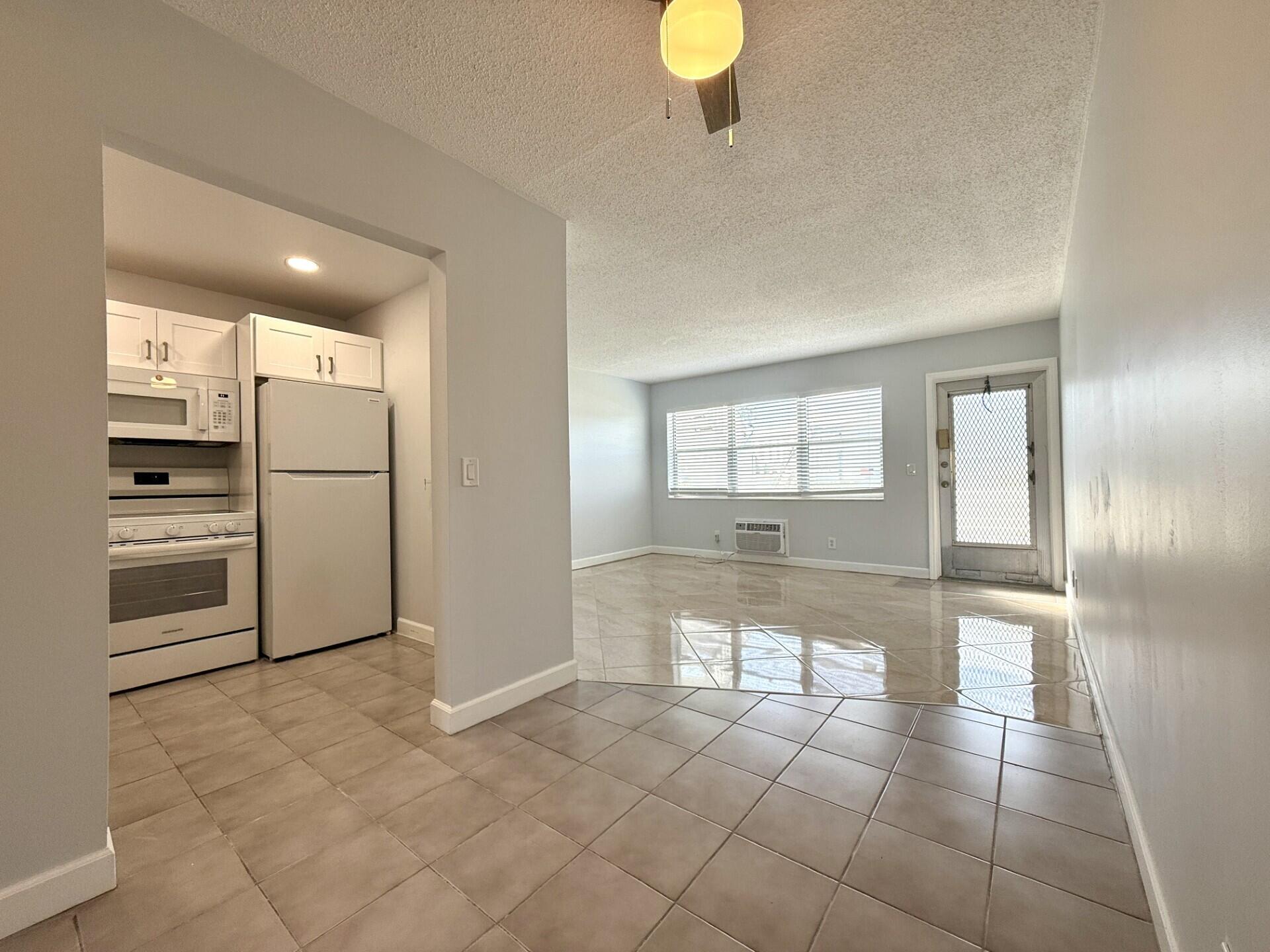 85 Berkshire D West Palm Beach, FL 33417 - Photo 7 of 17 a view of a refrigerator in kitchen and wooden floor