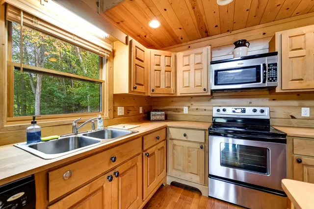 a kitchen with stainless steel appliances granite countertop a sink a stove and cabinets