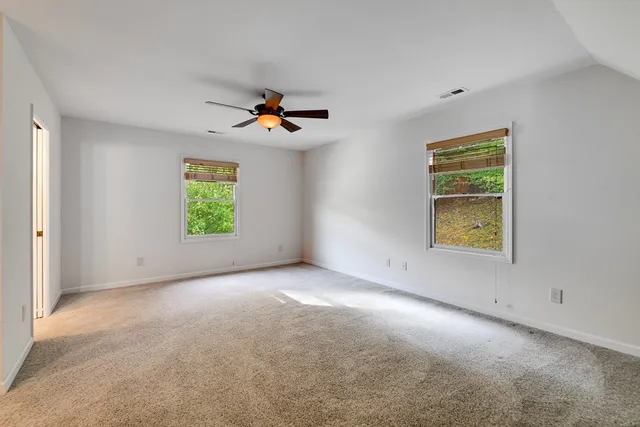 an empty room with closet and windows