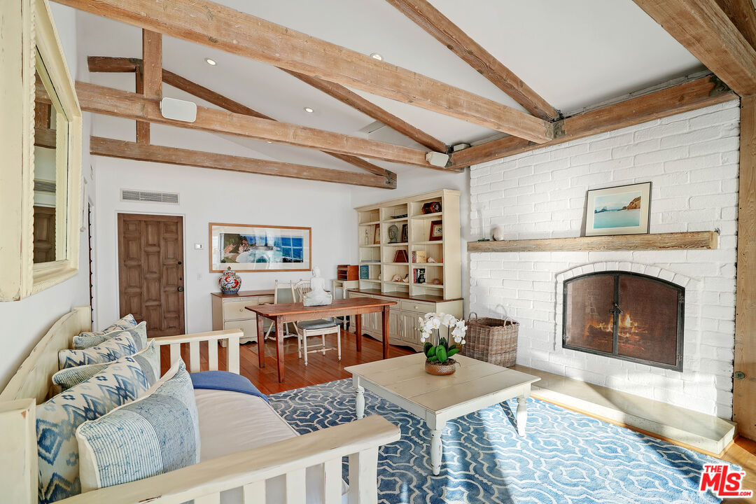 23422 Malibu Colony Road, Unit 98 Malibu, CA 90265 - Photo 23 of 53 a living room with furniture a fireplace and a table