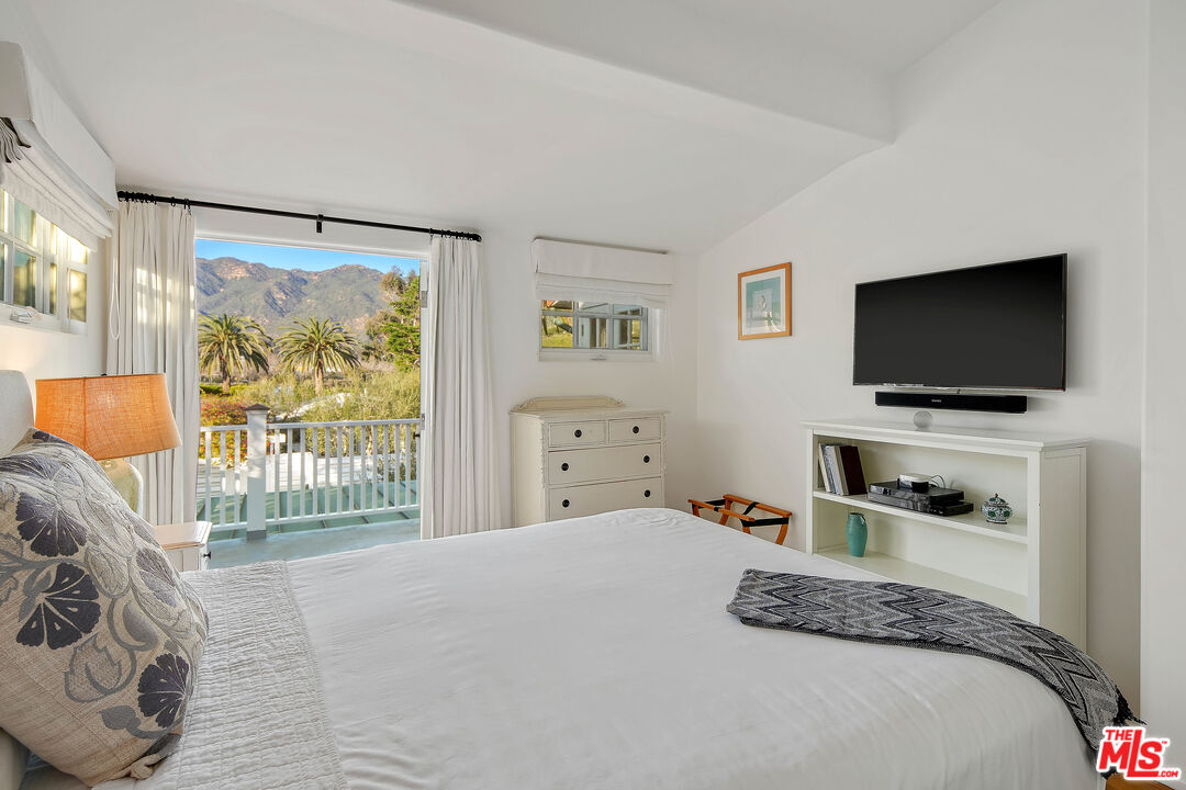 23422 Malibu Colony Road, Unit 98 Malibu, CA 90265 - Photo 29 of 53 a bedroom with a bed and a flat screen tv