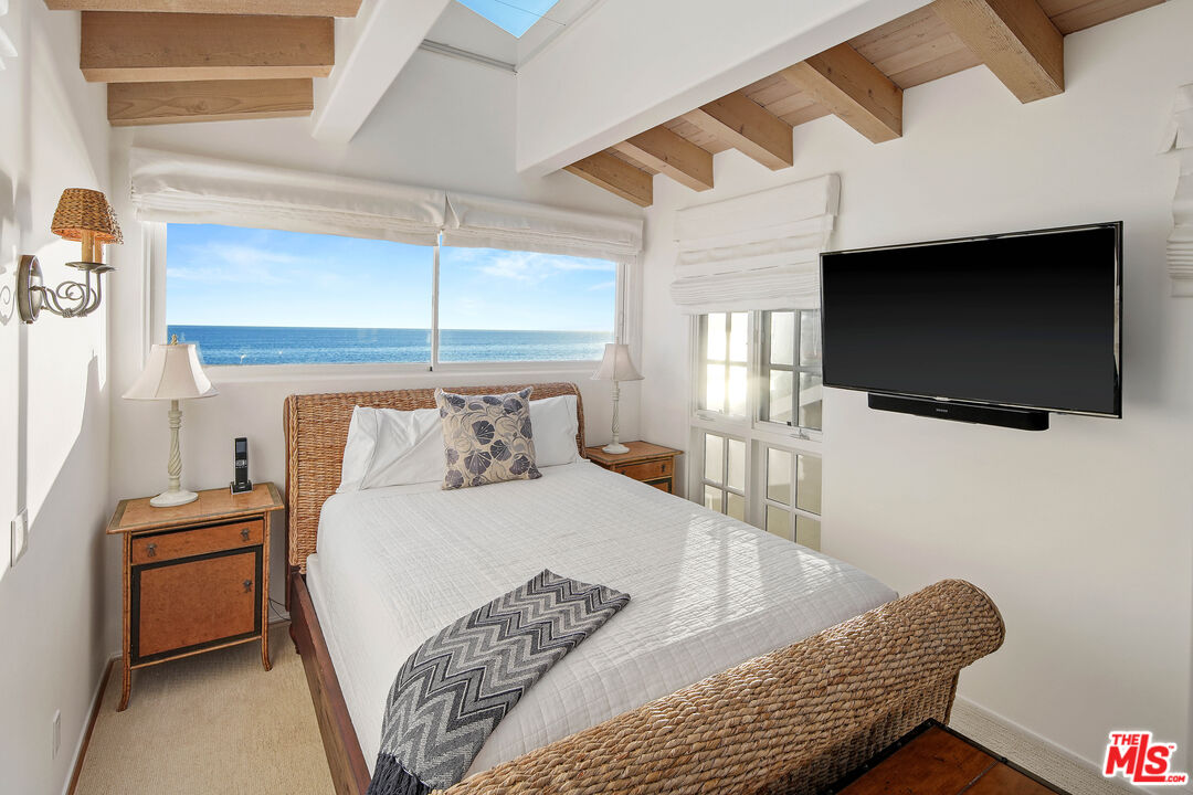 23422 Malibu Colony Road, Unit 98 Malibu, CA 90265 - Photo 35 of 53 a bedroom with a bed and a flat screen tv
