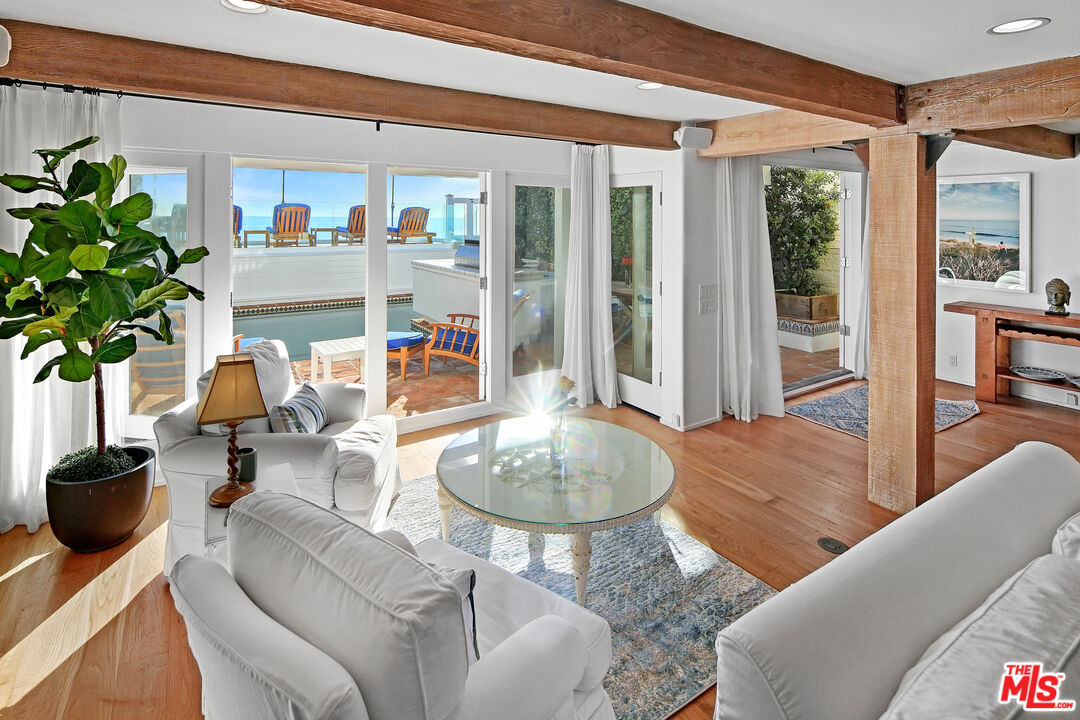 23422 Malibu Colony Road, Unit 98 Malibu, CA 90265 - Photo 8 of 53 a living room with furniture a dining table and a potted plant