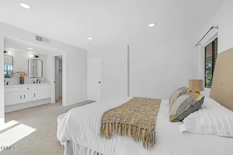 a bedroom with a bed and a large mirror