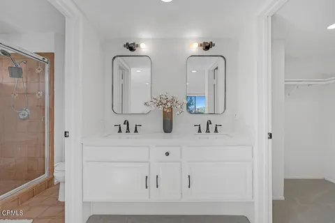 a bathroom with mirror two sinks a mirror and vanity