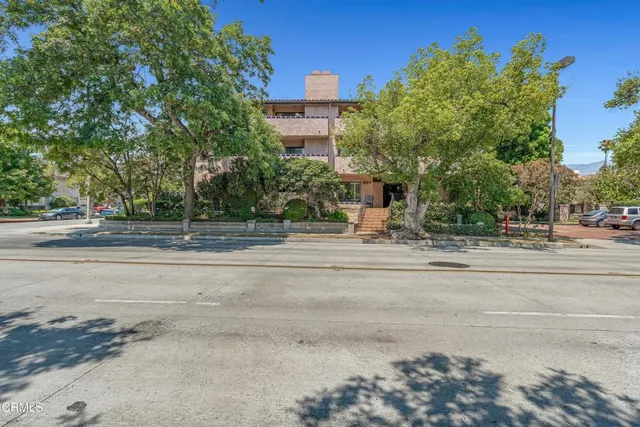 a man walking down a street next to a building
