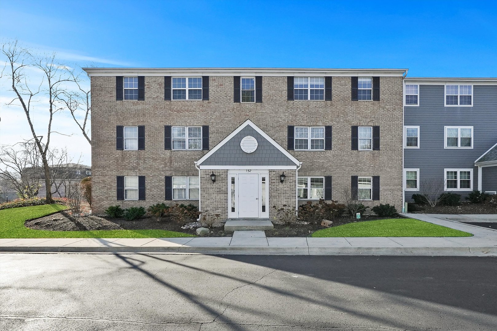 152 East Winchester Road, Unit E Libertyville, IL 60048 - Photo 1 of 24 a front view of a house with a garden and plants