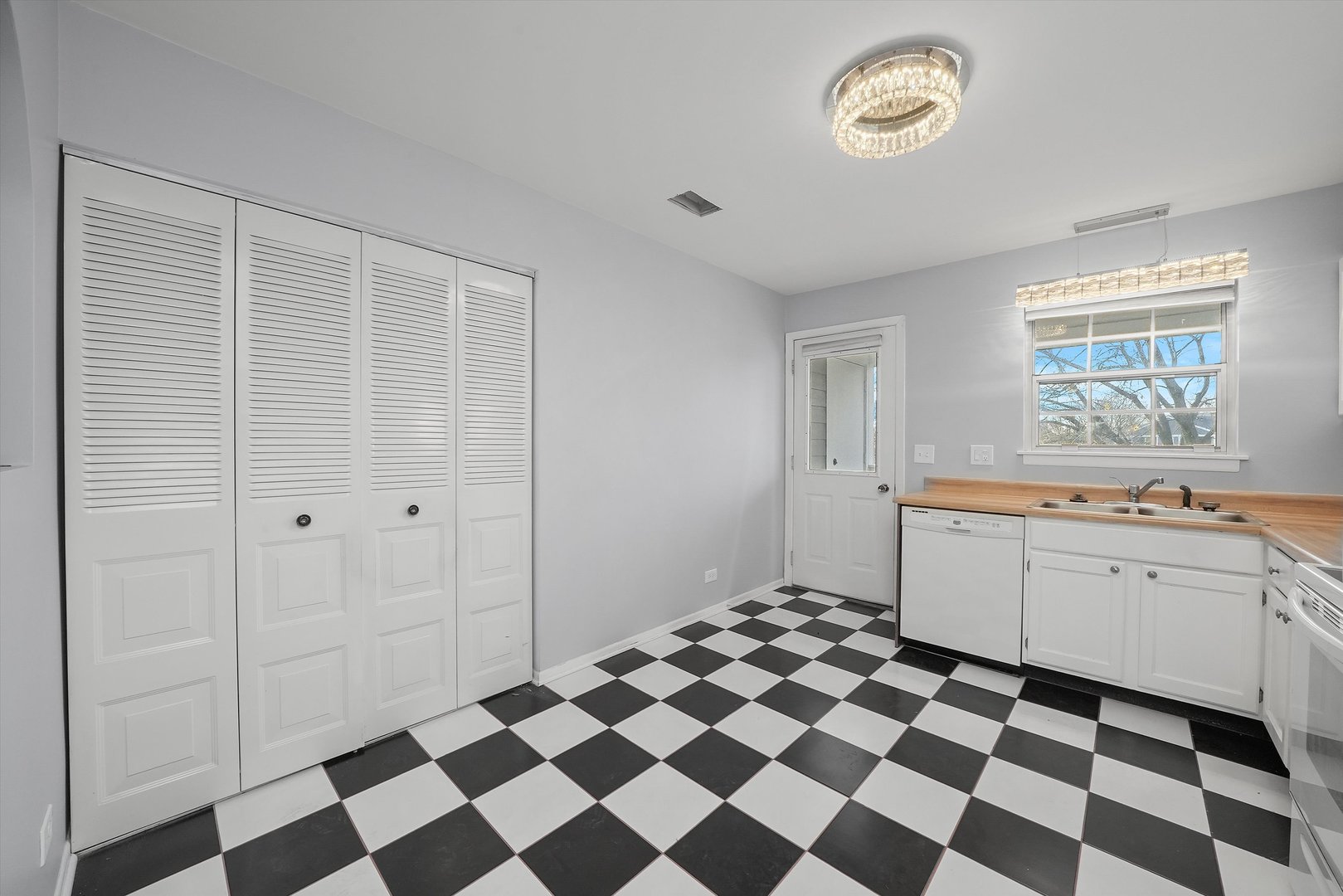 152 East Winchester Road, Unit E Libertyville, IL 60048 - Photo 12 of 24 a kitchen with a checkered floor and white cabinets