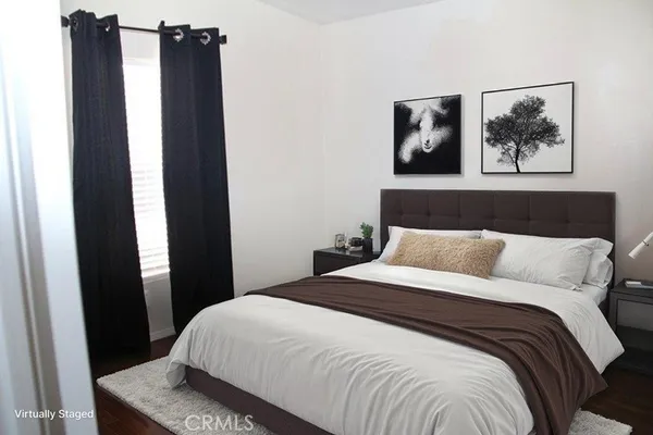 a bedroom with a bed and painting on the wall
