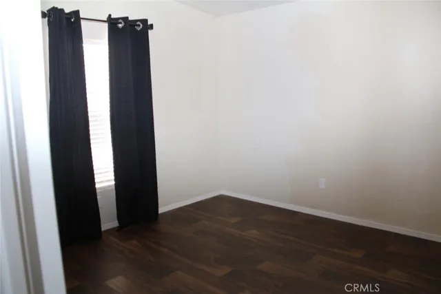 a view of a hallway with wooden floor and closet