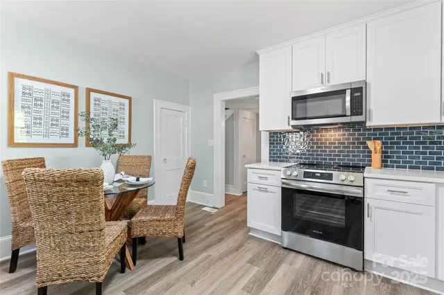 a kitchen with a stove top oven cabinetry a sink and a microwave