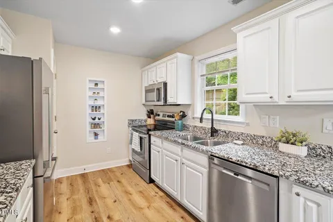 a kitchen with stainless steel appliances granite countertop a sink stove and refrigerator