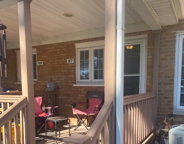 a view of a balcony with chair and brick wall