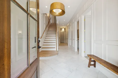 a view of a hallway with entryway wooden floor and staircase