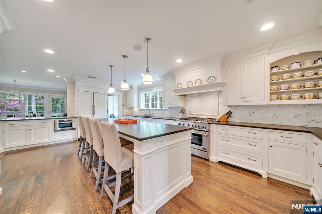 227 Fairmount Road Ridgewood, NJ 07450 - Photo 18 of 50 a kitchen with stainless steel appliances granite countertop wooden floor sink stove and white cabinets with wooden floor