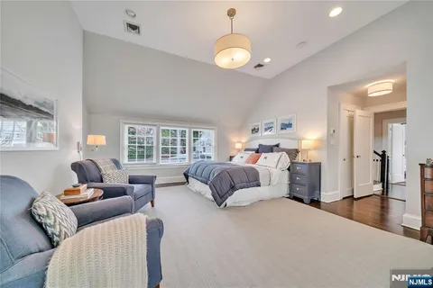 a bedroom with a bed couches and window