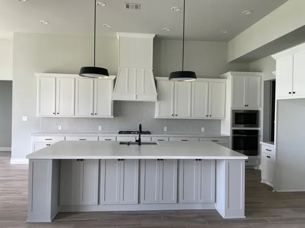 a kitchen with stainless steel appliances granite countertop a sink a stove and a refrigerator