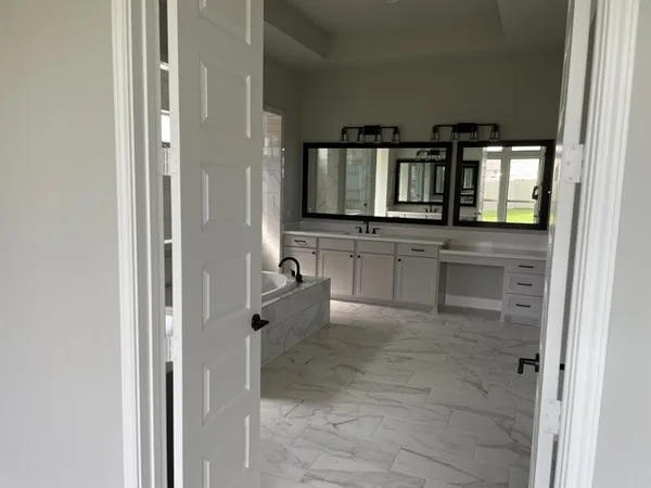a bathroom with a tub sink and mirror