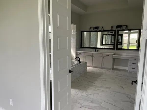 a bathroom with double vanity and a bathtub