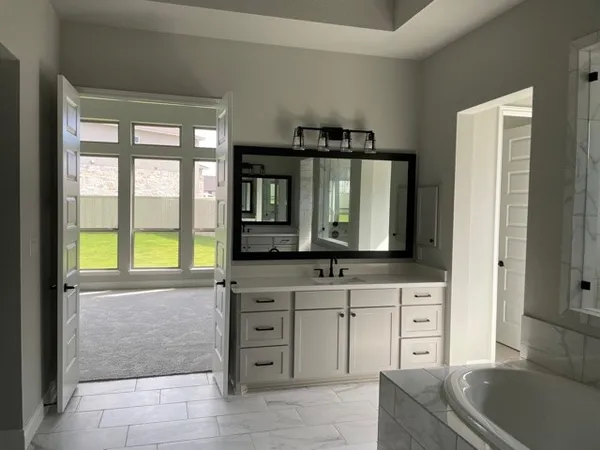 a bathroom with a bathtub sink and mirror