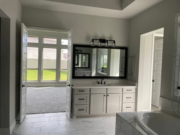 a bathroom with a bathtub sink and mirror