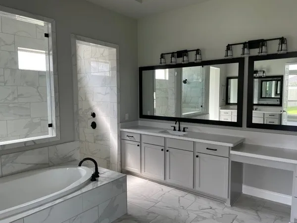 a bathroom with a tub sink and mirror