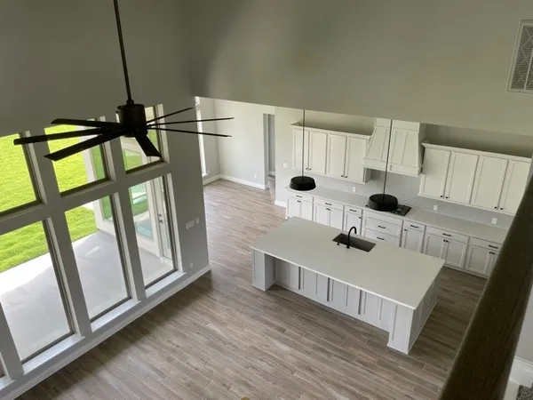 a kitchen with stainless steel appliances a stove a sink a refrigerator wooden floor and cabinets