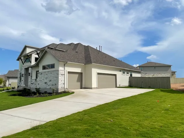 a view of a house with a big yard and large trees