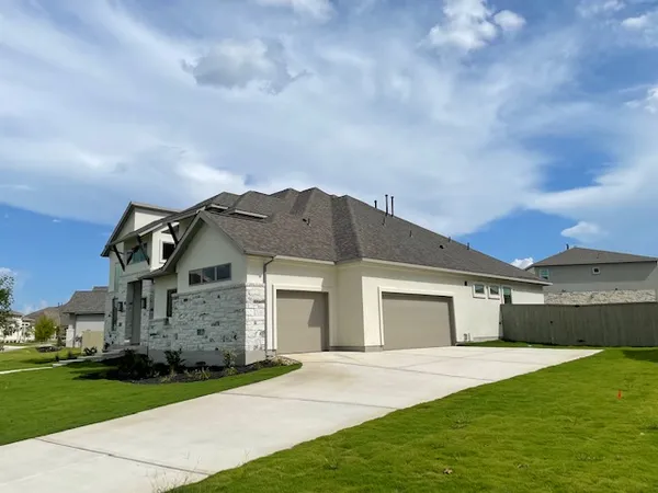 a front view of a house with a garden and yard