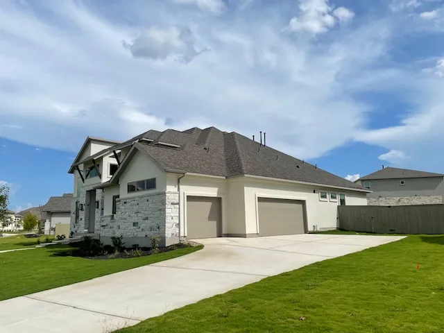 a front view of a house with a garden and yard