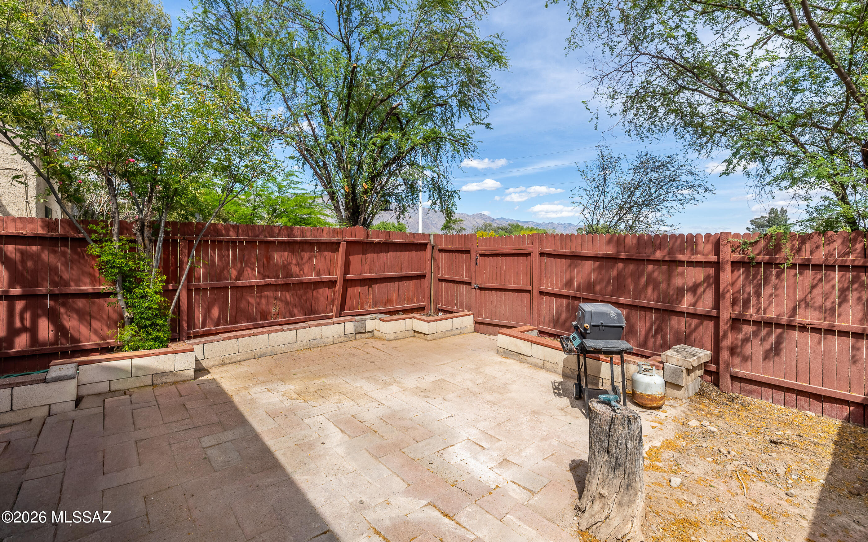 3750 North Country Club Road, Unit 46 Tucson, AZ 85716 - Photo 18 of 34 a view of backyard with wooden fence and large trees