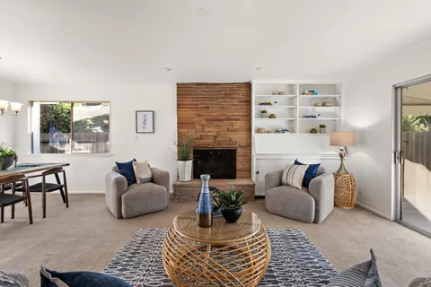 a living room with furniture a fireplace and a table