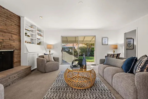 a living room with furniture a flat screen tv and a fireplace